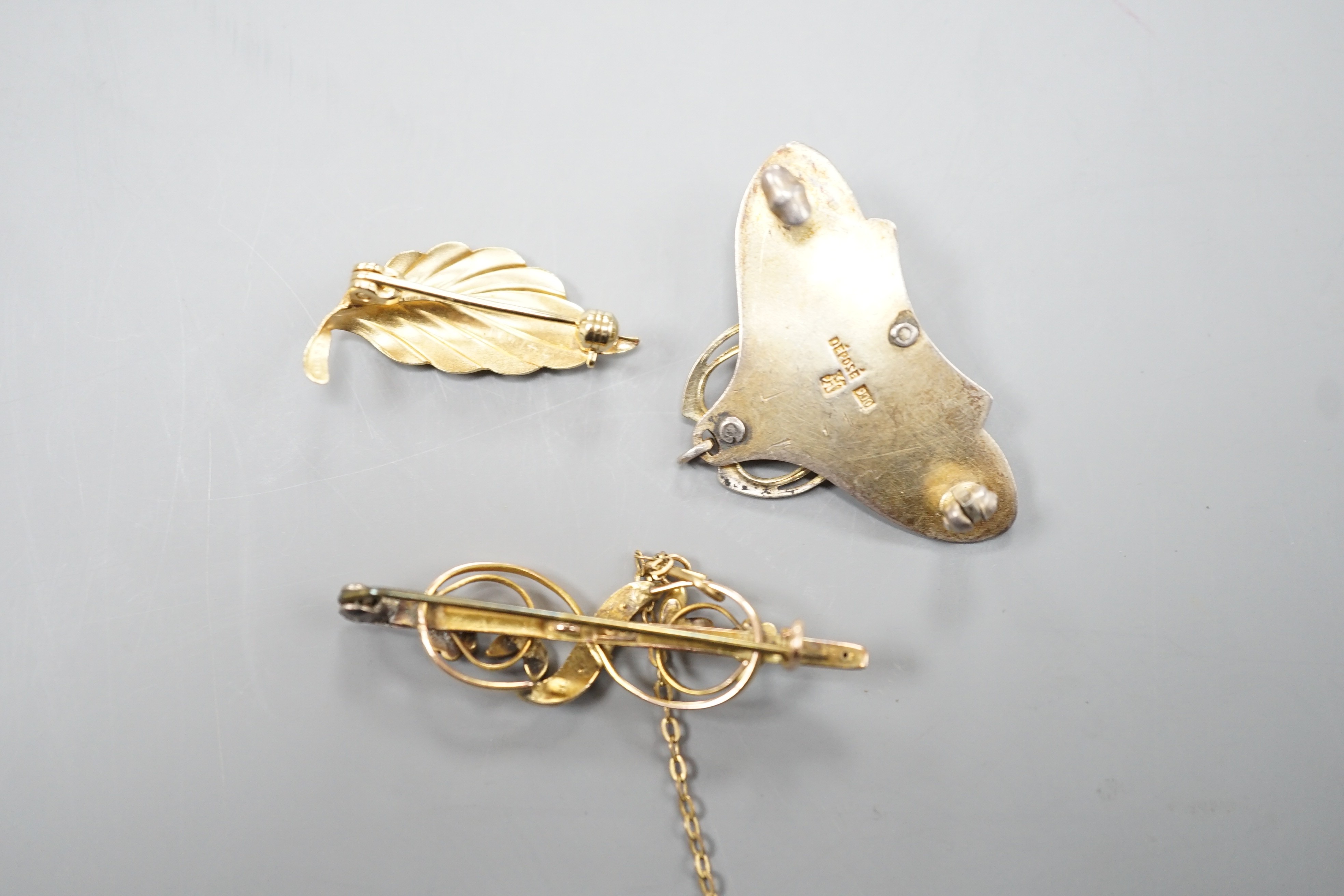 A continental Art Nouveau 900 gilt white metal, cabochon stone, seed pearl and enamel set brooch, 36mm and two 9ct brooches including gem set, 9ct gross 4.2 grams.